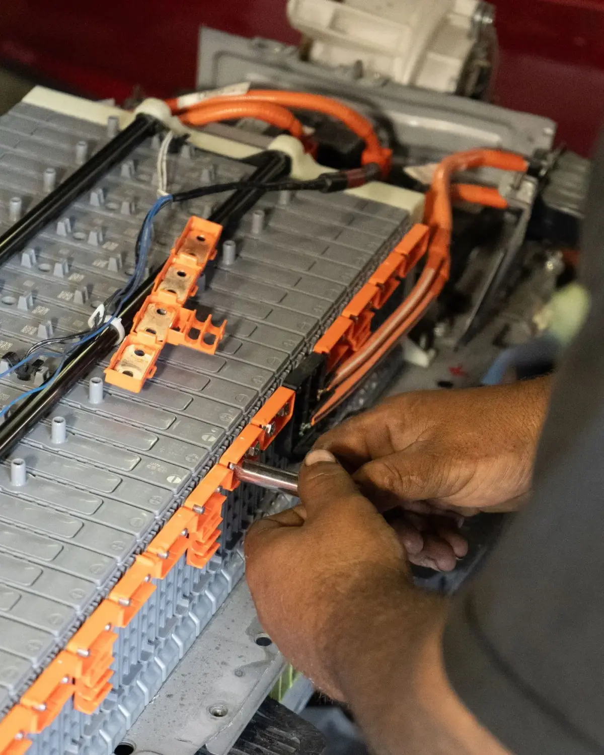 Technician repairing a Tesla high-voltage battery module