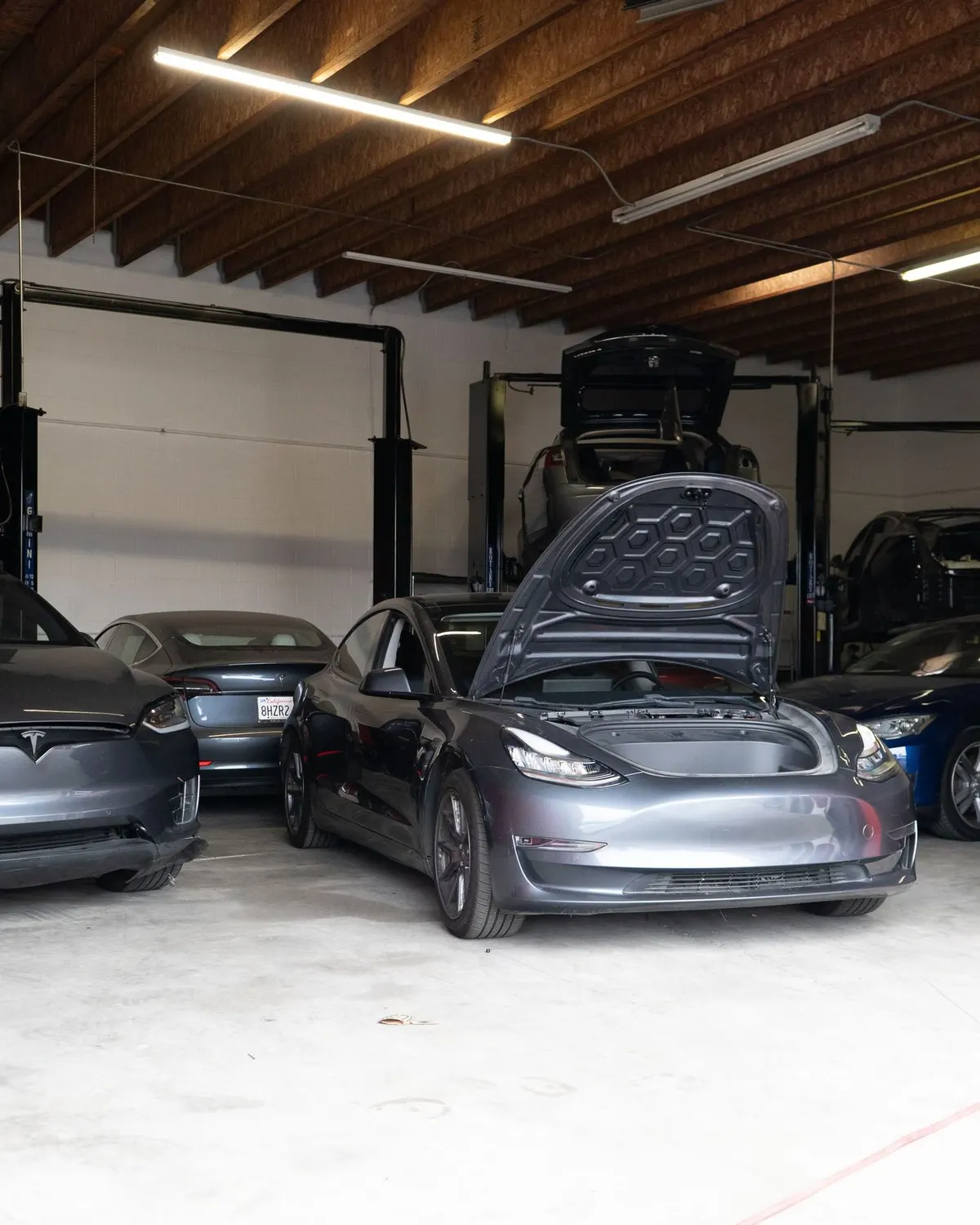 Tesla Model 3 with frunk open in the shop