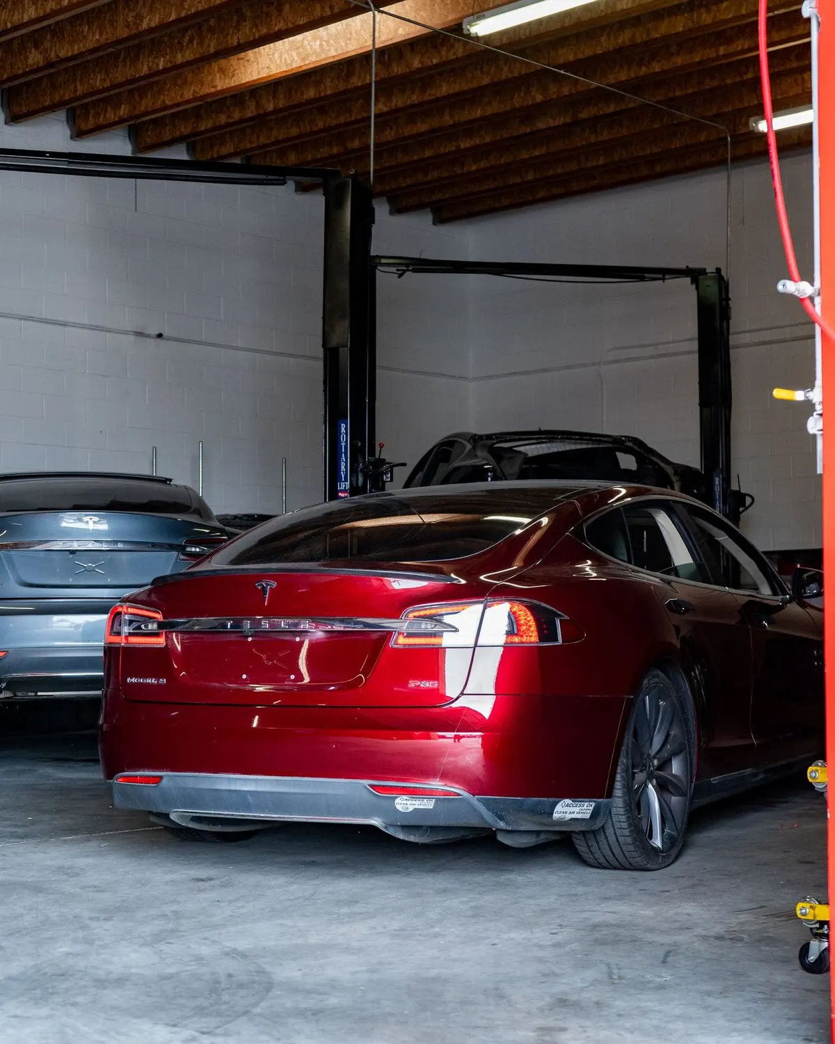 Red Tesla Model S in a service bay