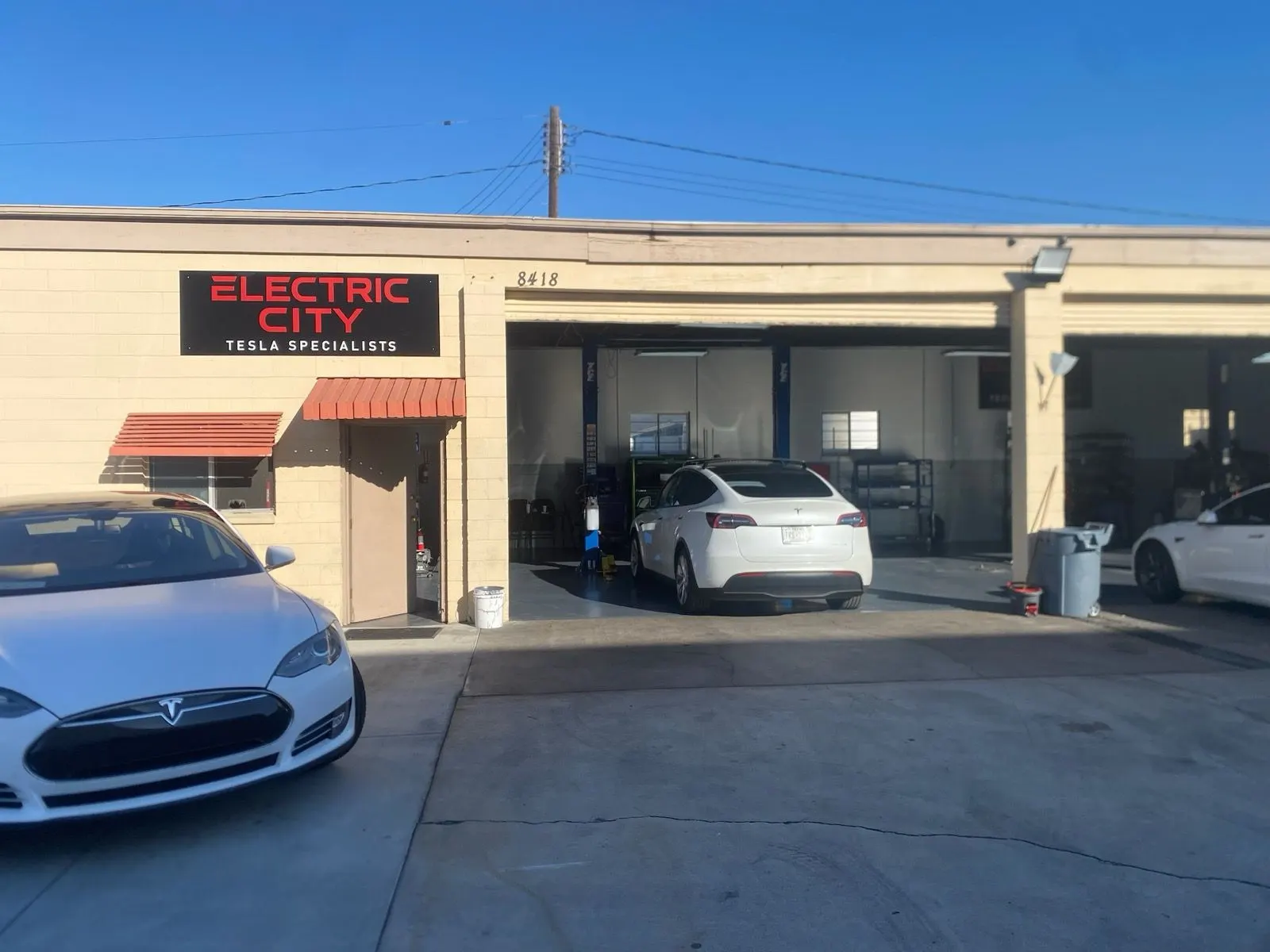 Electric City storefront at 8418 Katella Ave, Stanton, with Teslas parked out front
